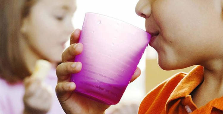 child drinking from cup